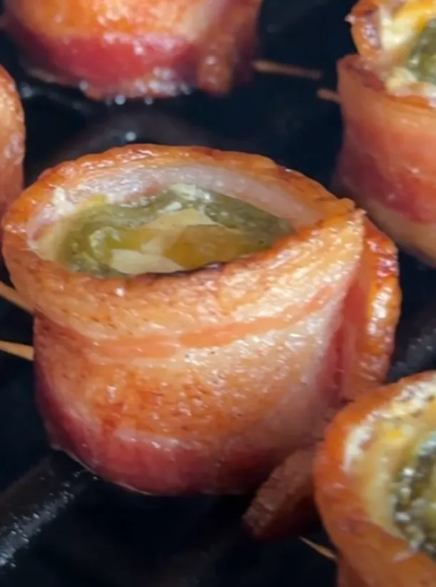 A close-up of the poppers cooking and crisping on the grill