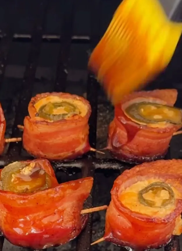 BBQ sauce being brushed over the poppers for a sticky glaze