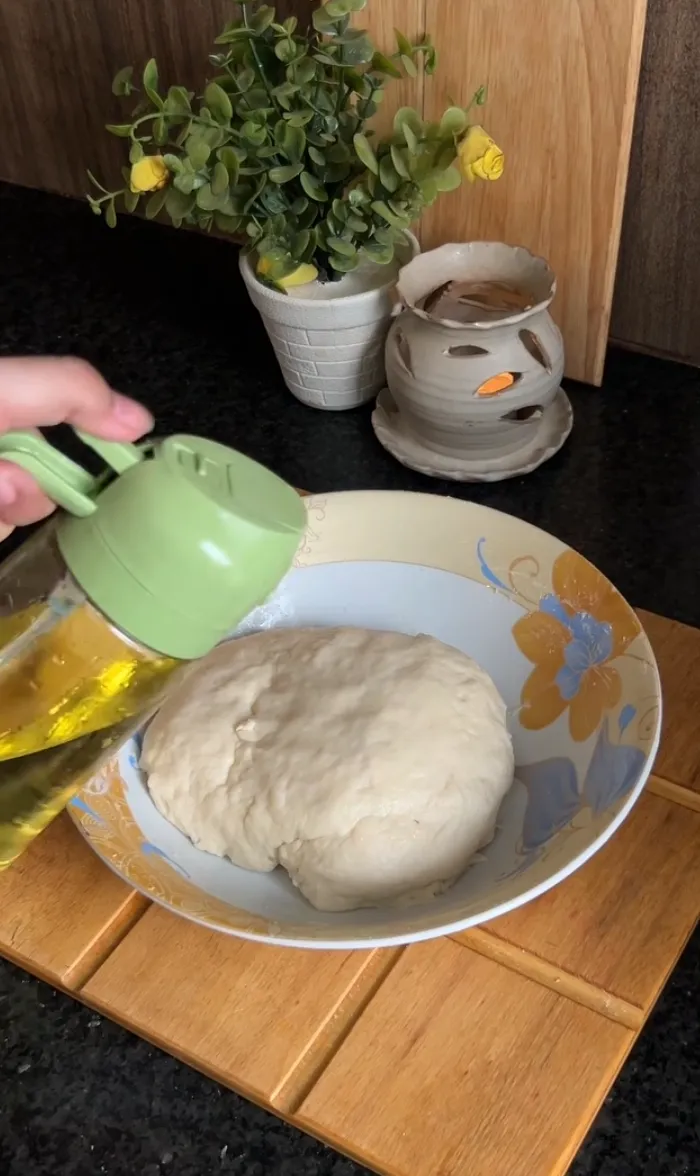 Soft risen bun dough resting in a bowl