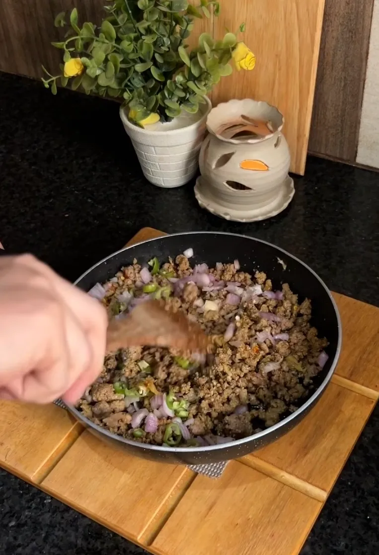 Spiced ground beef filling with onion and green chilli cooking in a pan