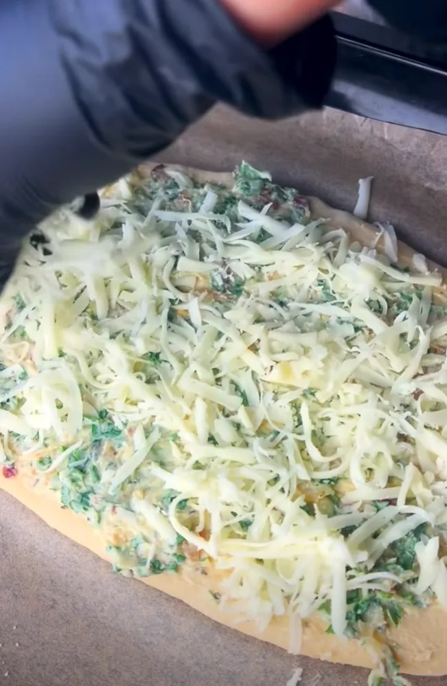 Grated cheese piled over the buttered dough