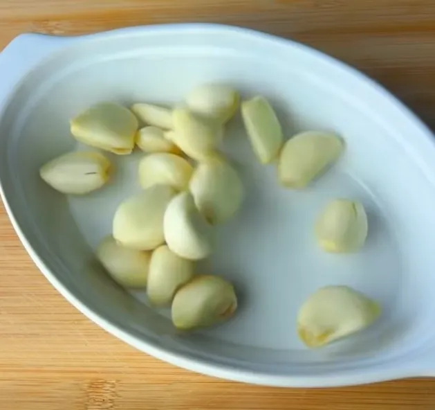 Peeled garlic cloves in a white dish