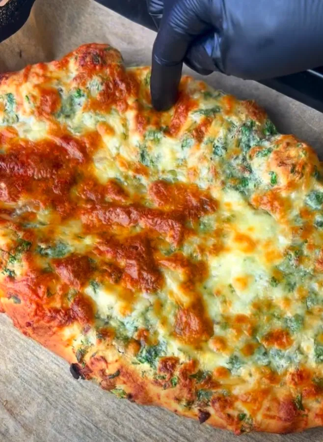 A whole homemade cheesy garlic bread, baked golden and bubbling on a tray