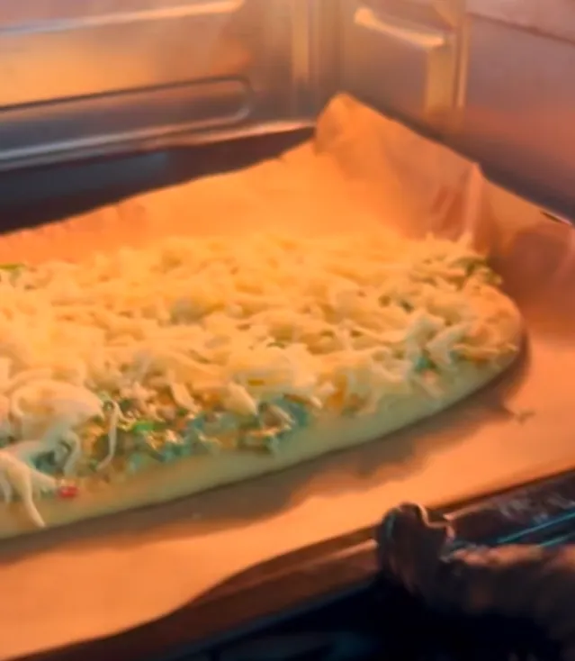 The cheesy garlic bread baking in the oven, cheese melting