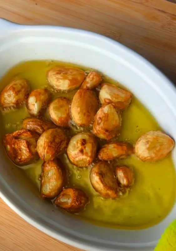 Roasted garlic cloves turned golden and soft in the oil