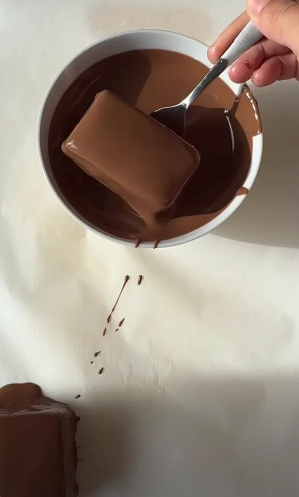 A bar fully coated in glossy melted milk chocolate