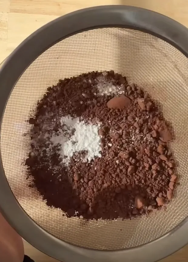 Cocoa powder and raising agents being sifted in