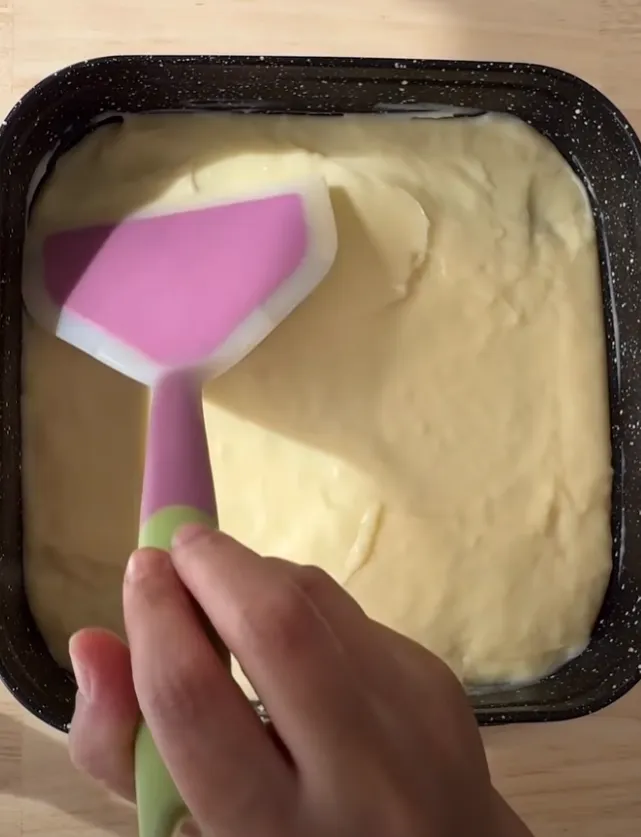 The milk cream layer spread smooth over the sponge