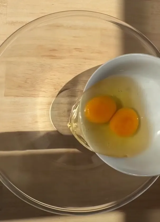 Two cracked eggs in a bowl ready to be whisked