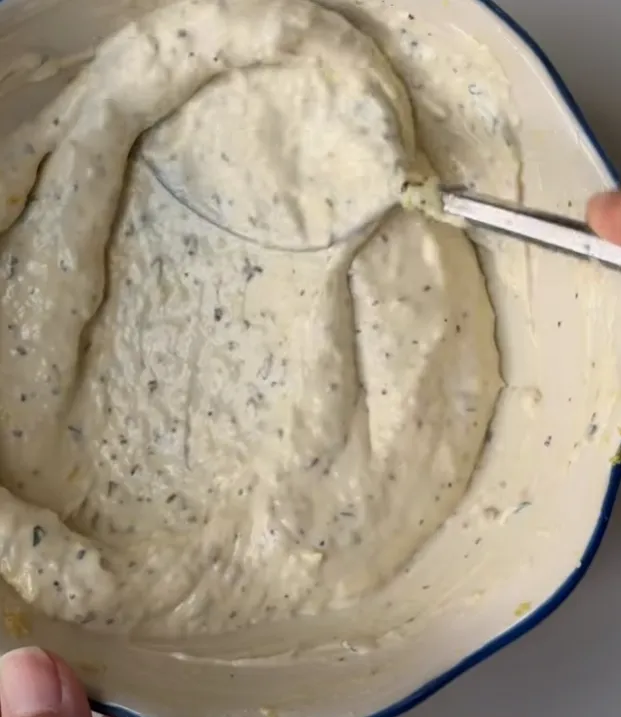 Creamy homemade caesar dressing being stirred smooth in a bowl