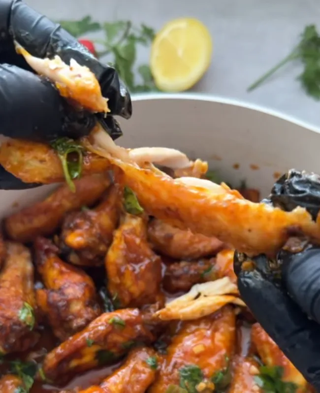 Finished honey chilli lemon chicken wings garnished with coriander in the pan