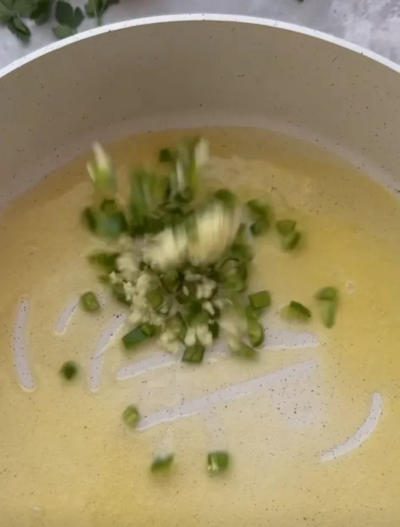 Melted butter in a pan with chopped garlic, green chilli and spring onion