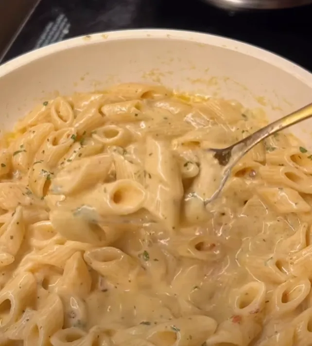 A close-up of creamy spicy garlic parmesan penne on a fork