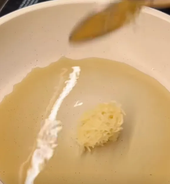 Finely grated garlic added to the melted butter in the pan